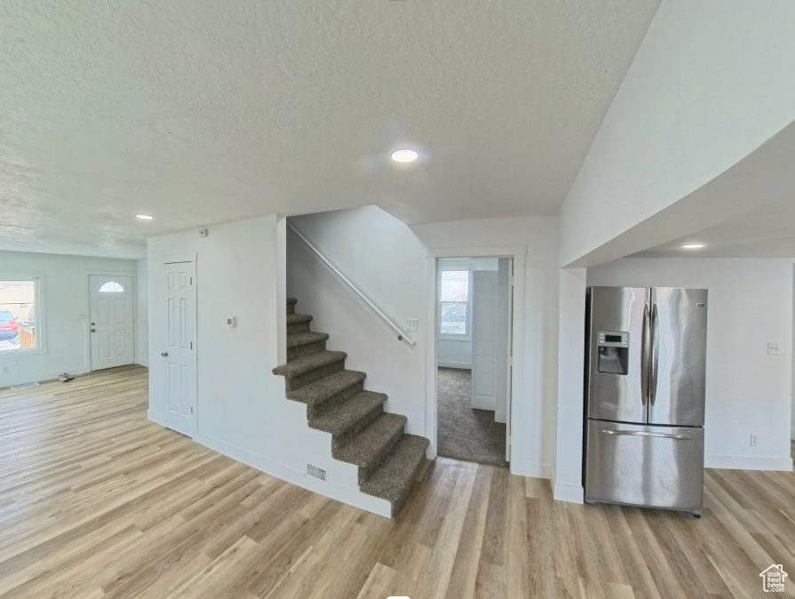 Interior space featuring wood finished floors, a textured ceiling, baseboards, and recessed lighting