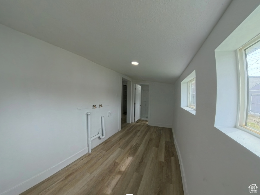 Spare room featuring light wood finished floors, plenty of natural light, baseboards, and recessed lighting