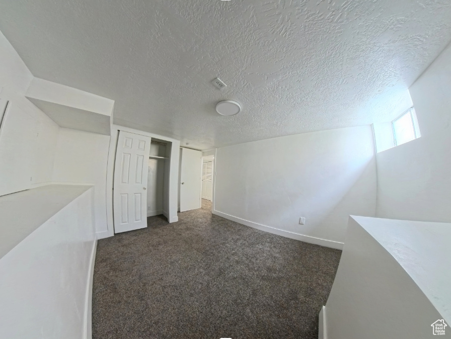 Spare room featuring a textured ceiling and carpet