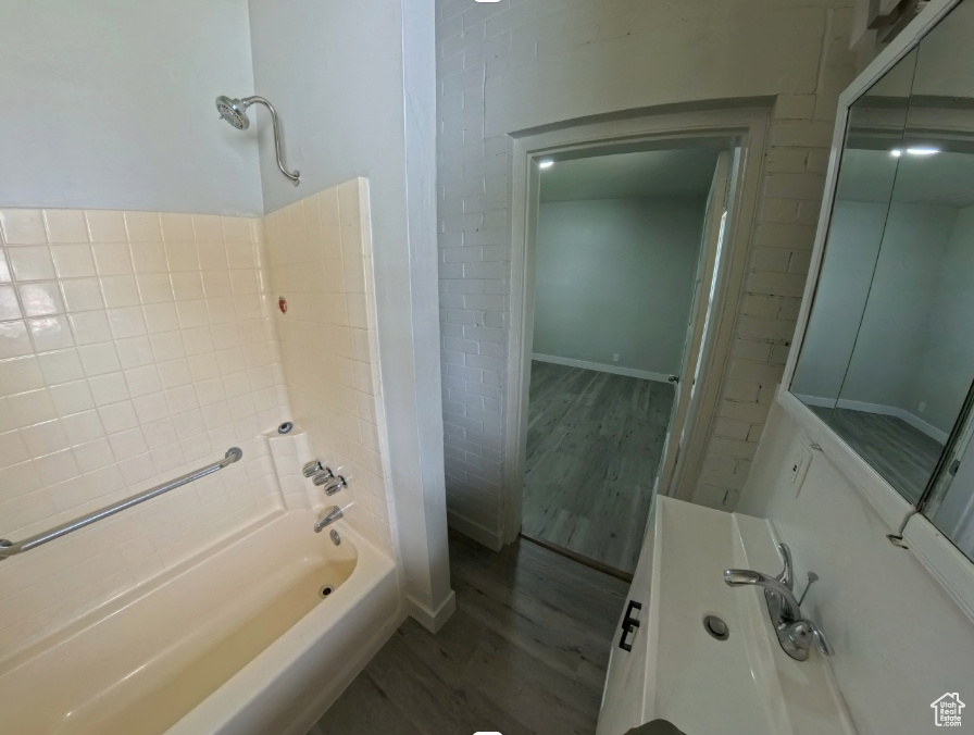 Full bath featuring wood finished floors and bathing tub / shower combination