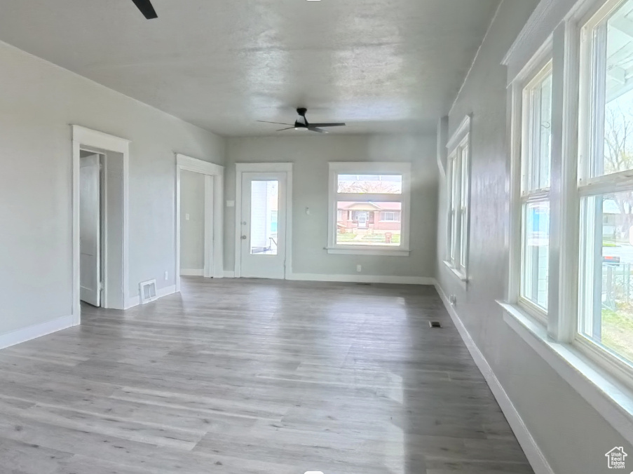 Spare room with a ceiling fan, wood finished floors, and baseboards