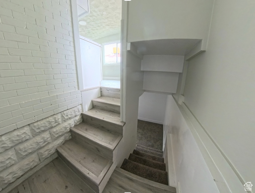 Stairway featuring a textured ceiling