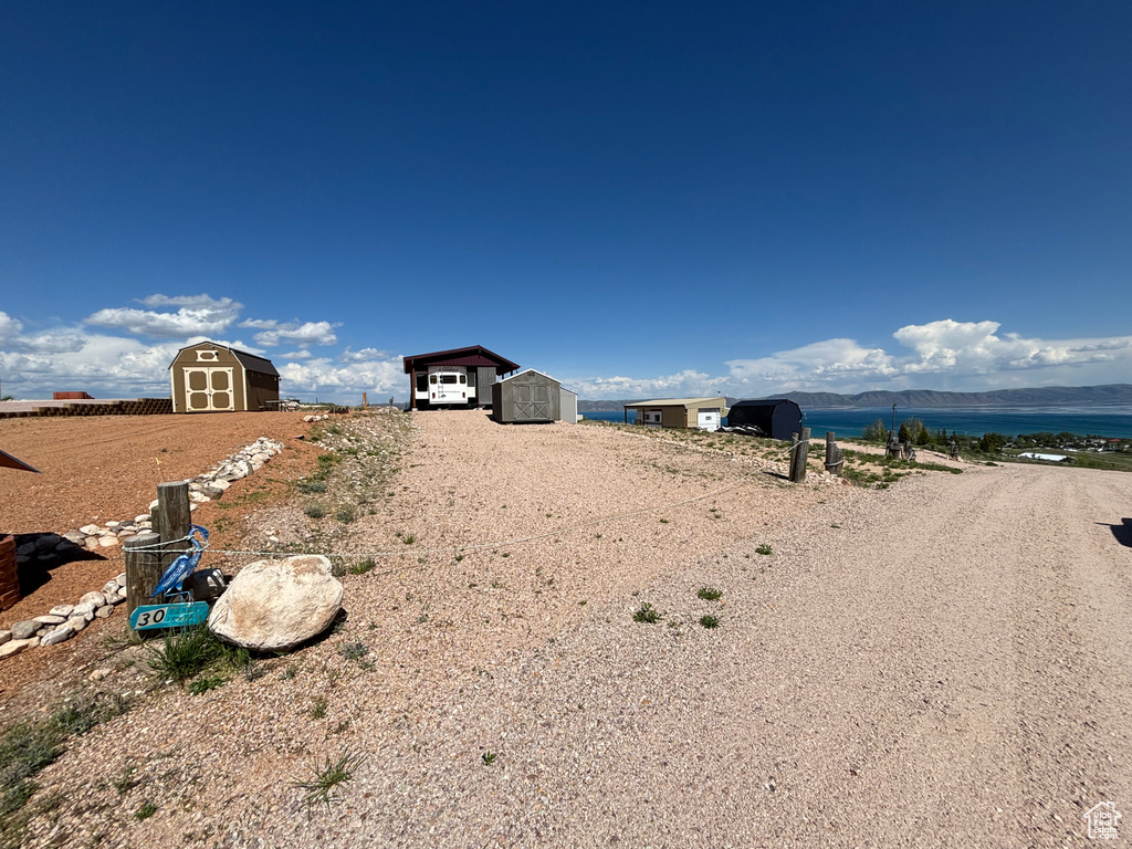 View of yard with driveway and a water view