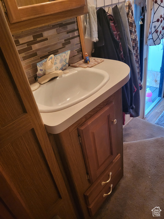 Bathroom featuring vanity and backsplash