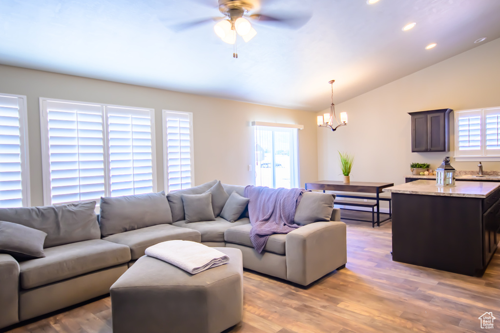 Living area with a chandelier, plenty of natural light, vaulted ceiling, ceiling fan, and recessed lighting
