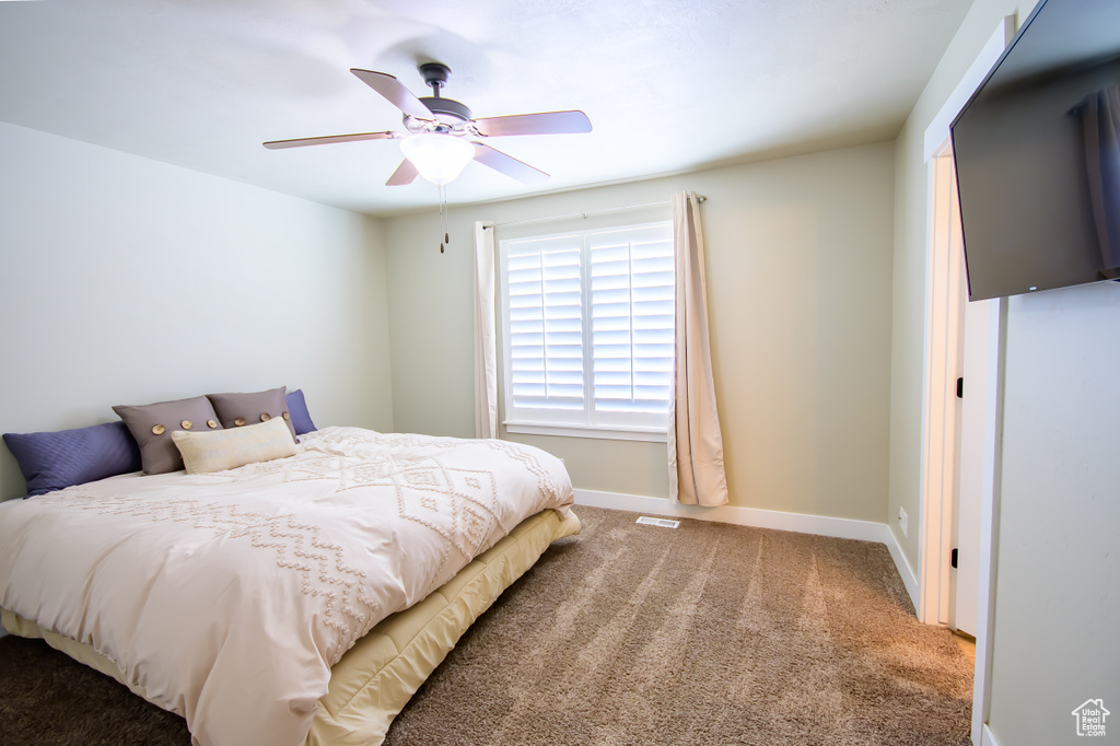 Bedroom with carpet floors, baseboards, and a ceiling fan