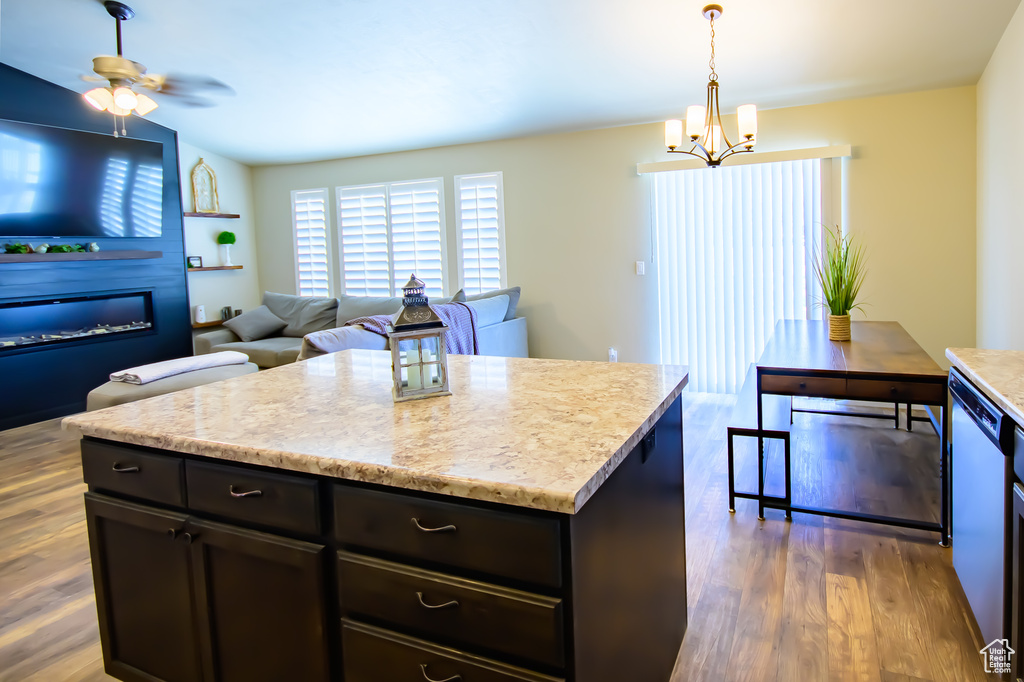 Kitchen with a chandelier, wood finished floors, dishwasher, and pendant lighting
