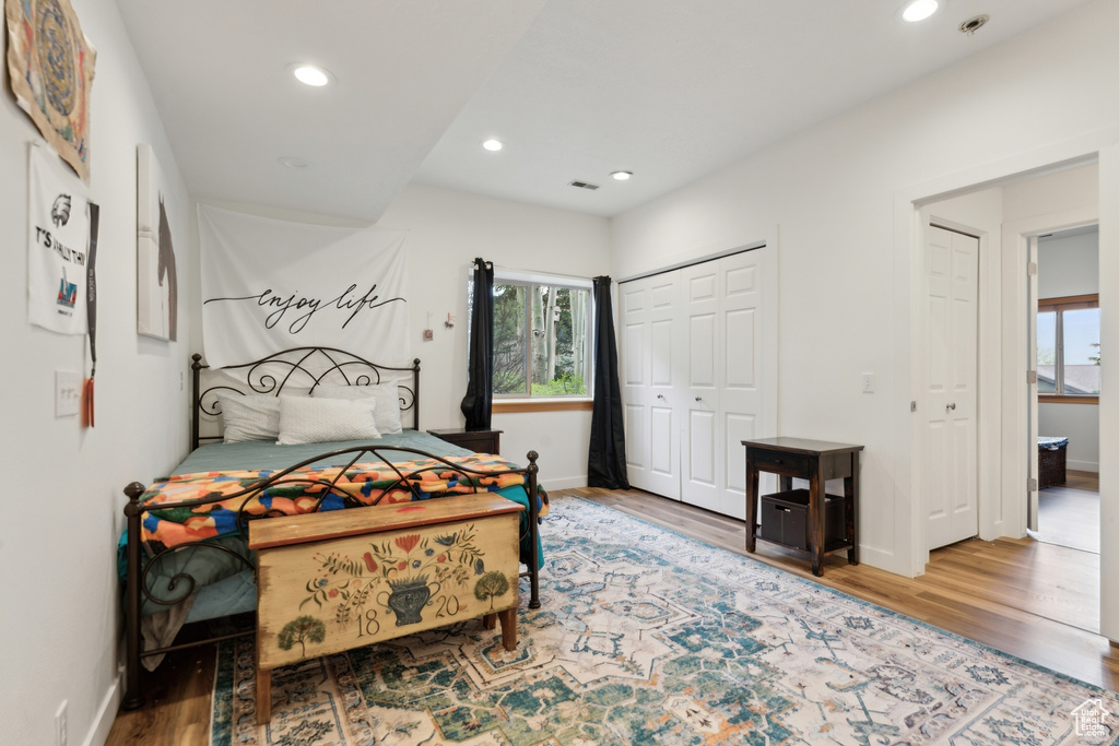 Bedroom featuring multiple windows, wood finished floors, recessed lighting, and baseboards