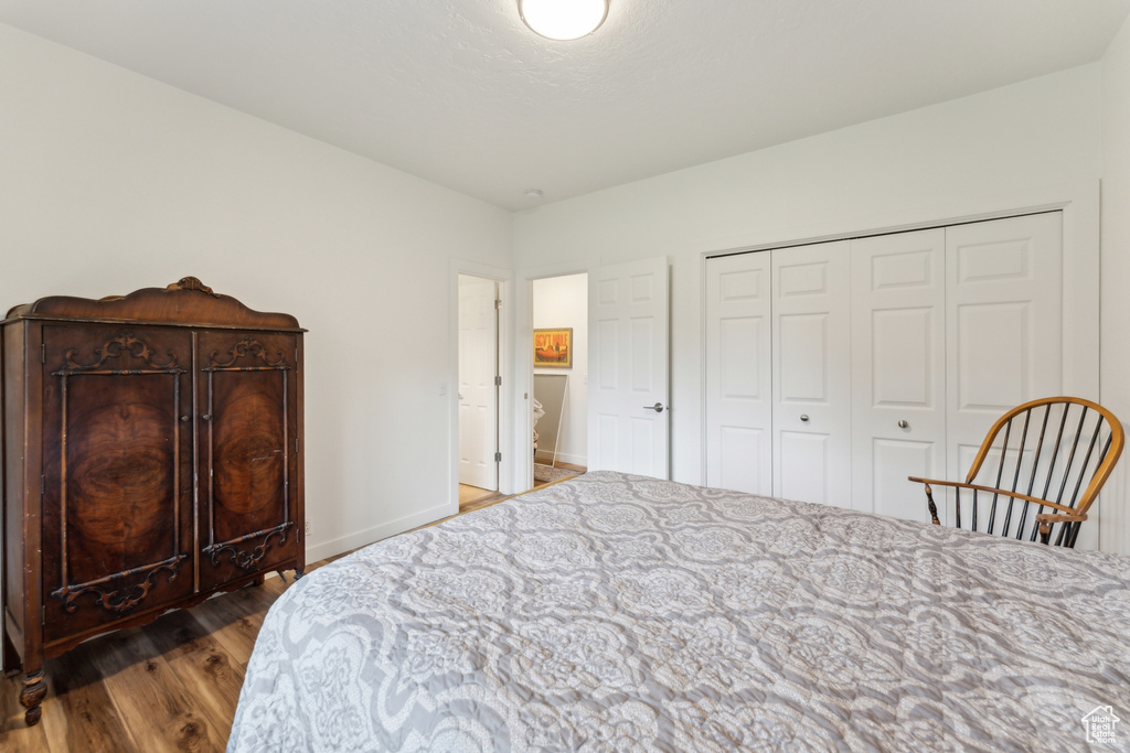 Bedroom featuring wood finished floors, a closet, and baseboards