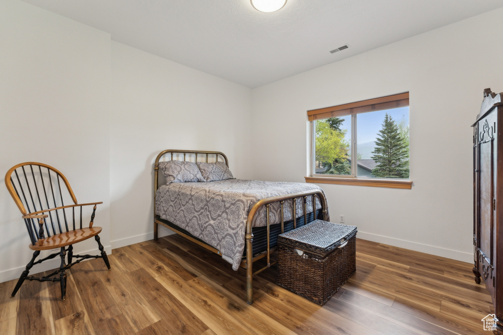 Bedroom featuring wood finished floors and baseboards
