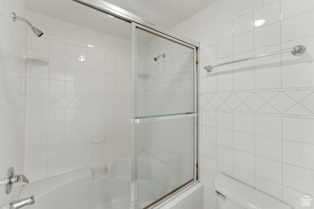 Full bath featuring enclosed tub / shower combo and toilet