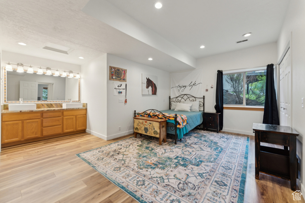 Bedroom with a sink, baseboards, recessed lighting, and light wood-type flooring