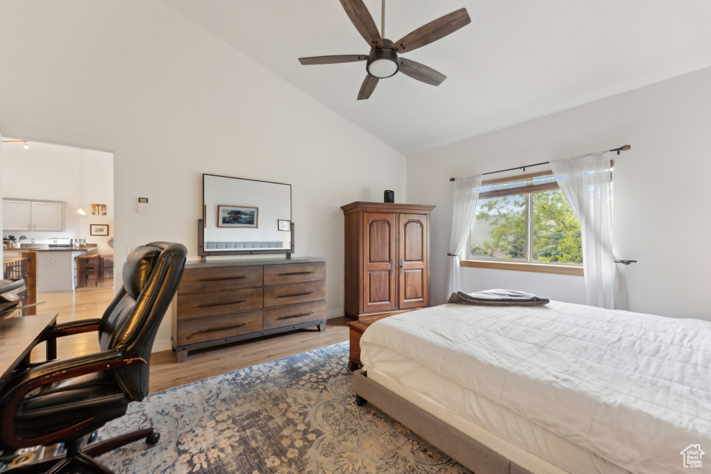 Bedroom featuring high vaulted ceiling, light wood-type flooring, a desk, and a ceiling fan