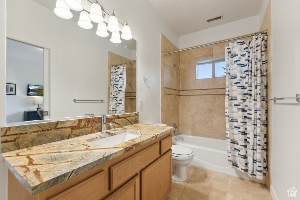 Full bathroom featuring toilet, vanity, shower / bath combo, and tile patterned flooring