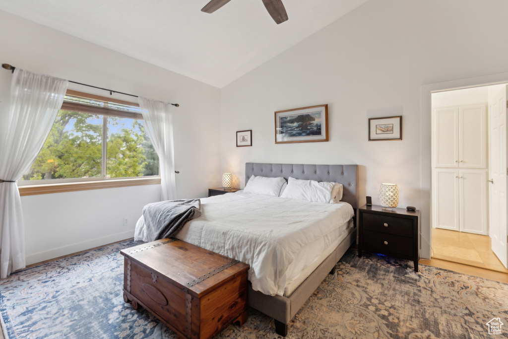 Bedroom with baseboards, a ceiling fan, and high vaulted ceiling