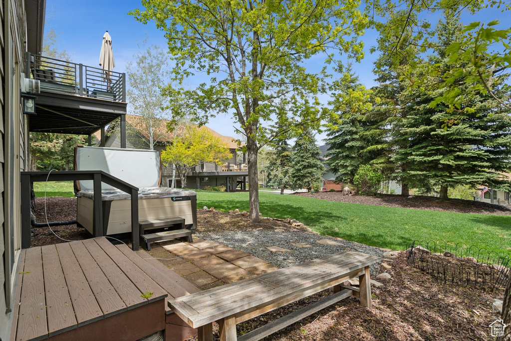 Wooden deck with a lawn and a hot tub