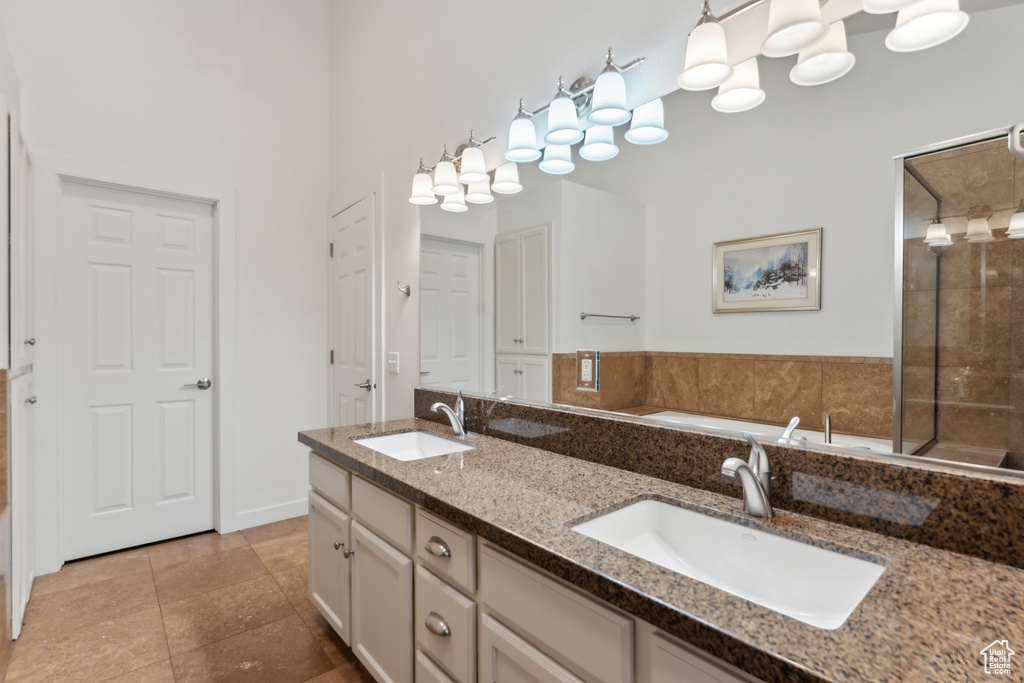 Bathroom featuring double vanity, a shower stall, a bath, and tile patterned flooring