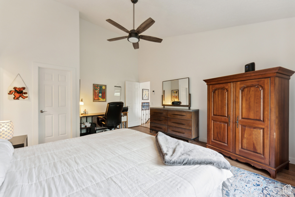 Bedroom featuring high vaulted ceiling, wood finished floors, a desk, and a ceiling fan
