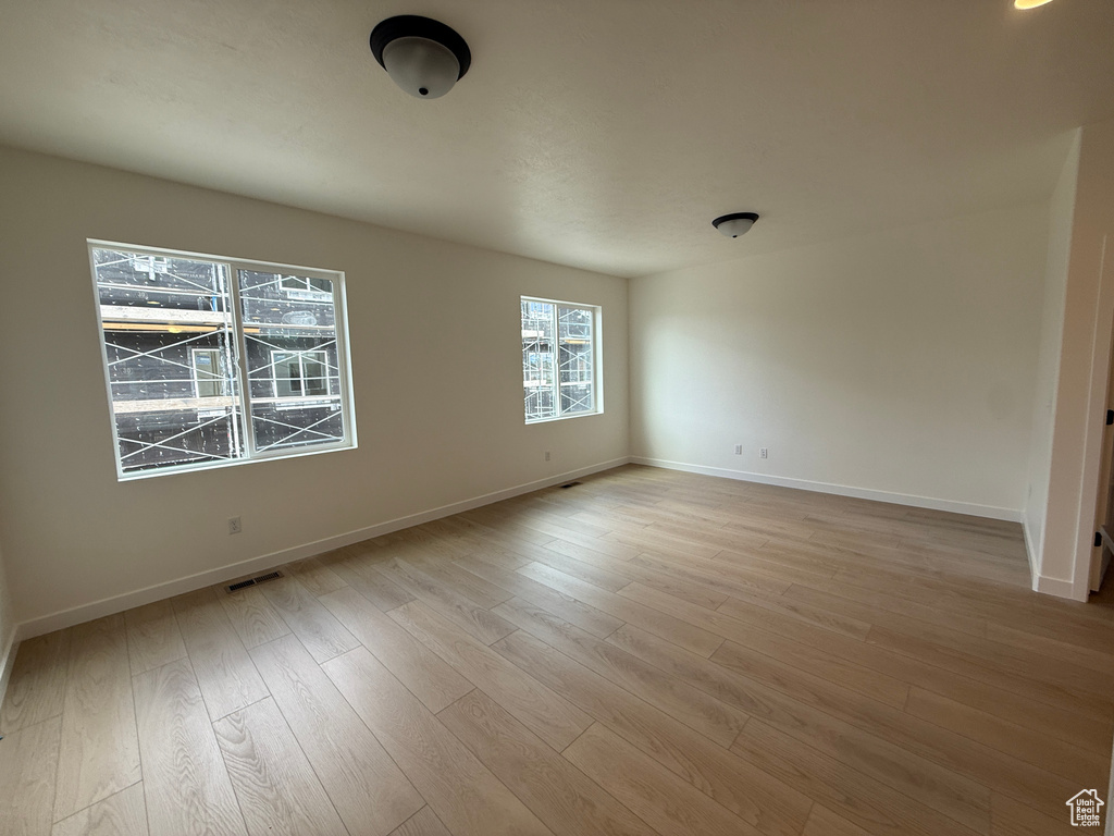 Unfurnished room with light wood-type flooring and baseboards