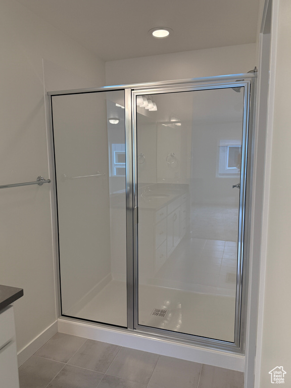 Bathroom with vanity, a shower stall, tile patterned flooring, and recessed lighting