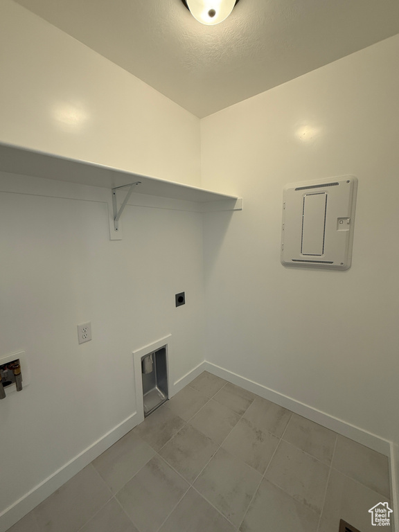 Washroom with washer hookup, baseboards, hookup for an electric dryer, and light tile patterned flooring