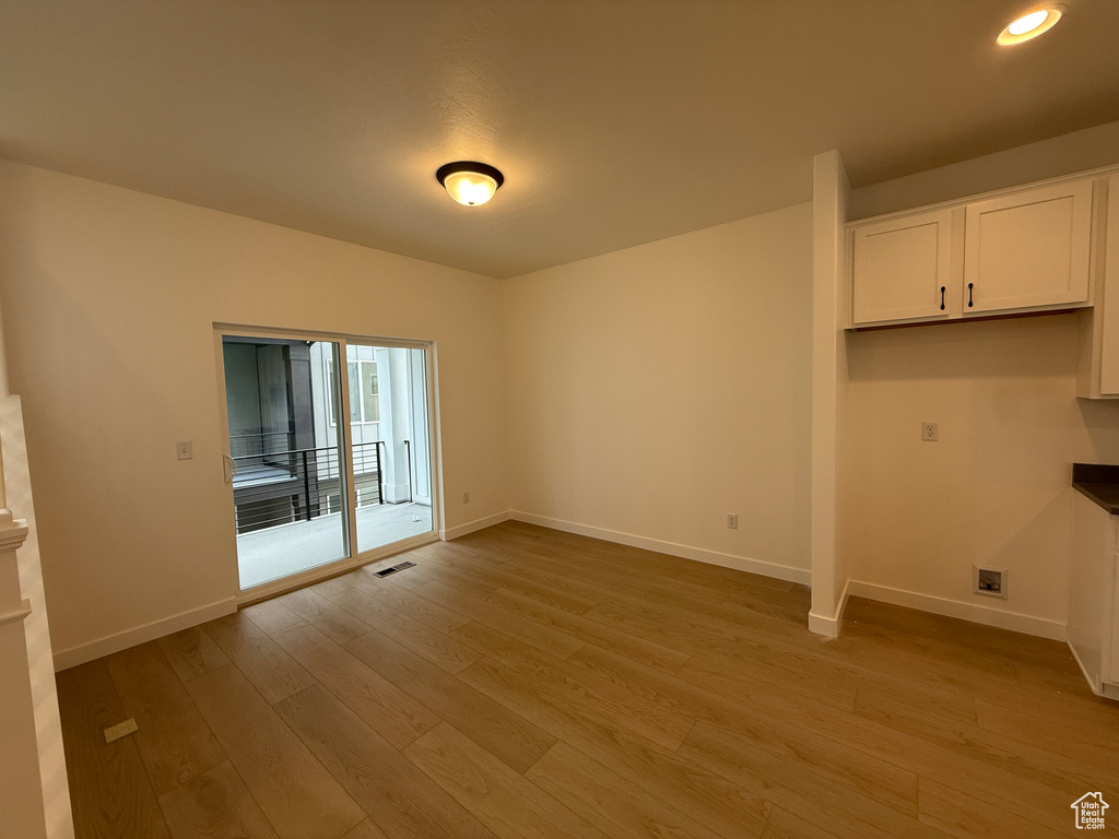 Spare room with light wood finished floors, baseboards, and recessed lighting