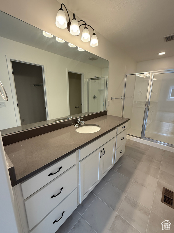Bathroom featuring a shower stall, vanity, and tile patterned flooring
