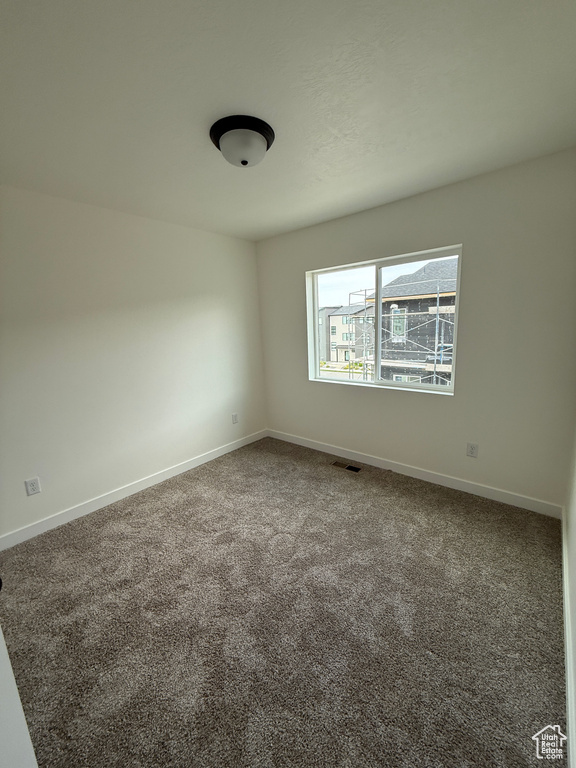 Carpeted spare room with baseboards