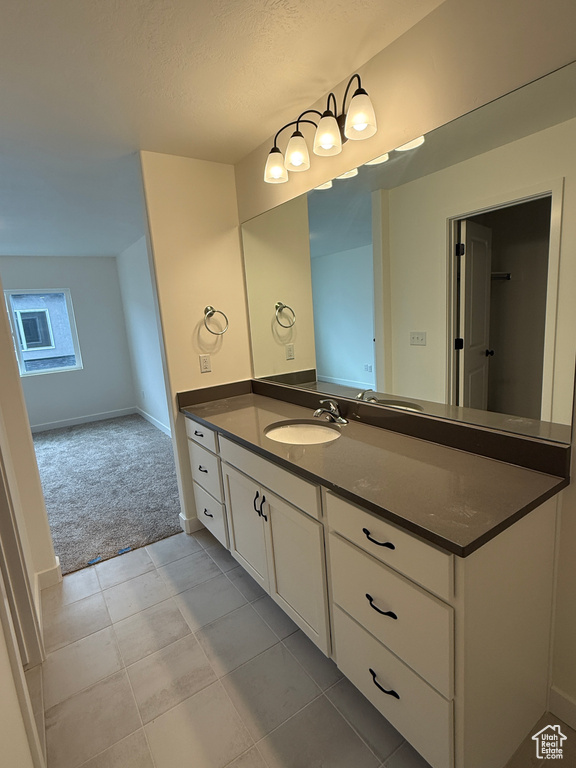 Bathroom with vanity, tile patterned floors, and baseboards