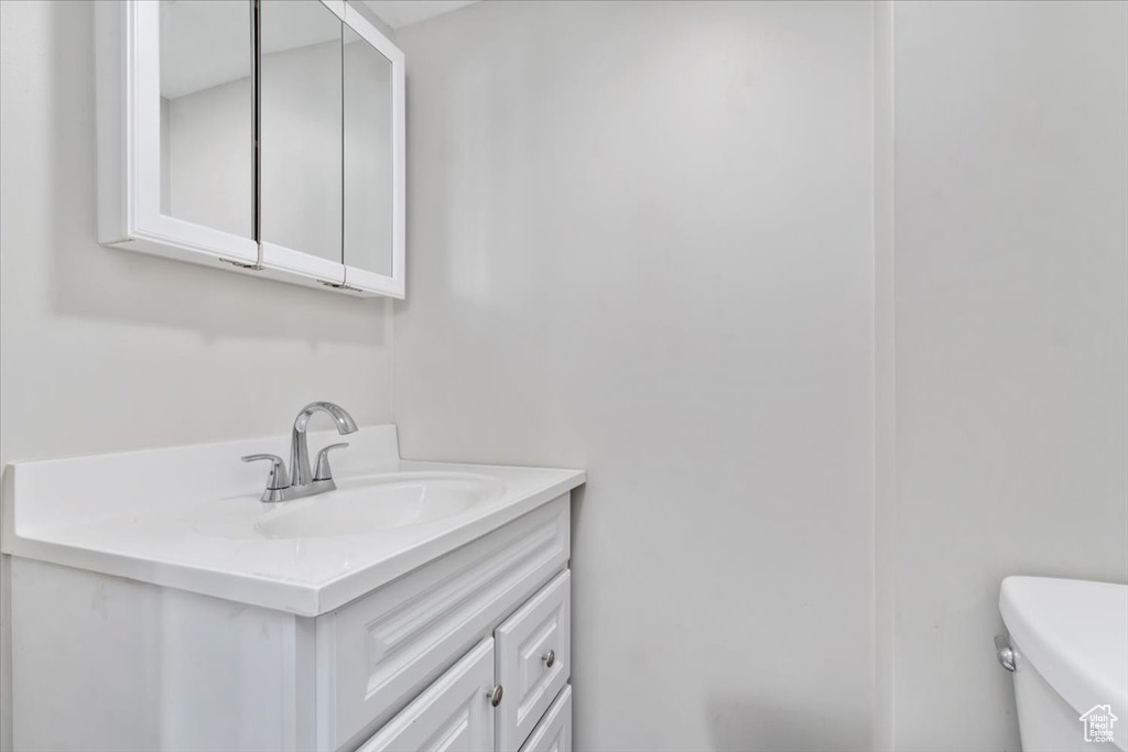 Half bath featuring toilet and vanity