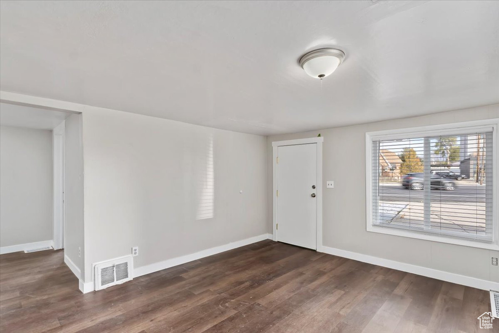 Foyer entrance with baseboards, dark wood finished floors, and visible vents