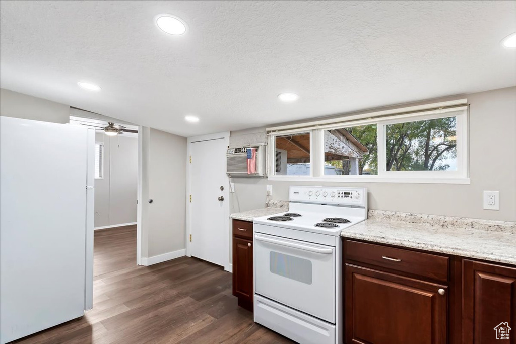 Kitchen with recessed lighting, dark wood finished floors, baseboards, and white appliances