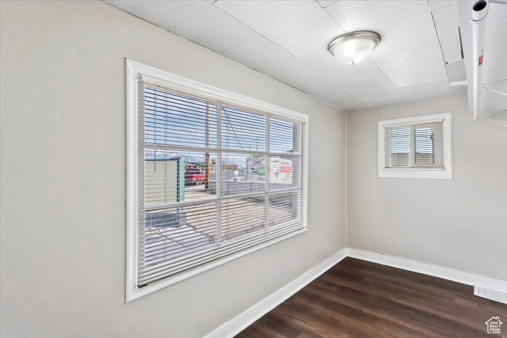 Spare room with visible vents, baseboards, and dark wood-style floors