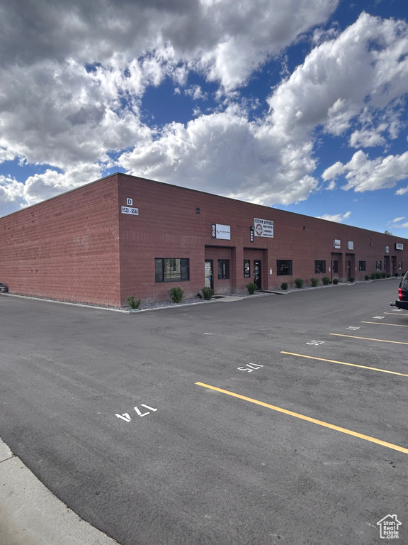 View of building exterior featuring uncovered parking