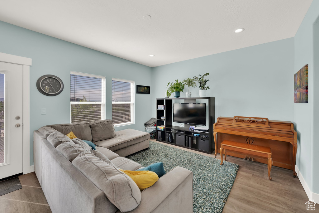 Living room featuring baseboards, recessed lighting, and wood finished floors