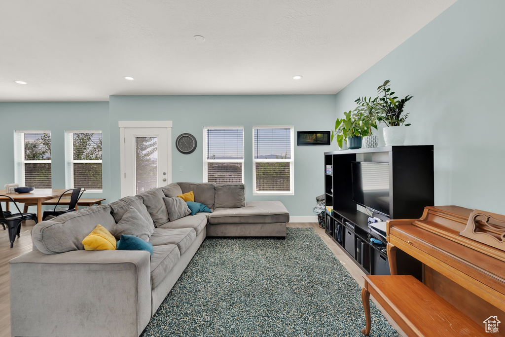 Living room with wood finished floors, recessed lighting, and baseboards