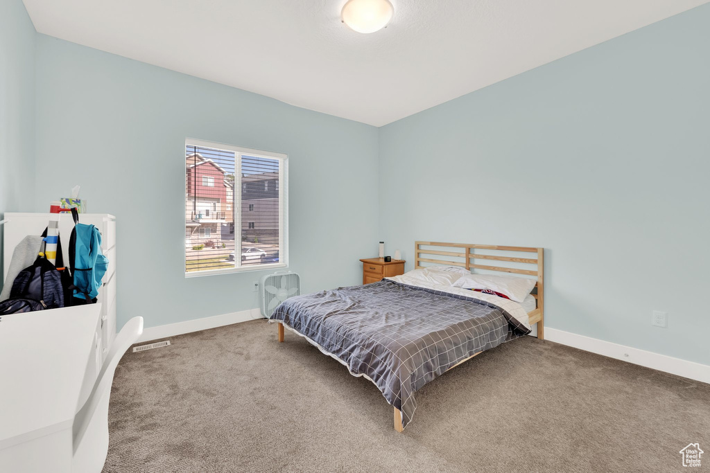 Bedroom featuring carpet and baseboards