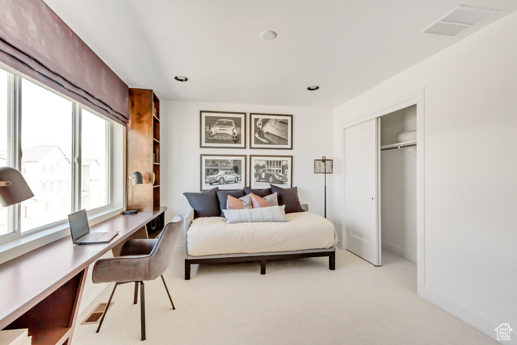 Bedroom with an office area, light carpet, a closet, and recessed lighting