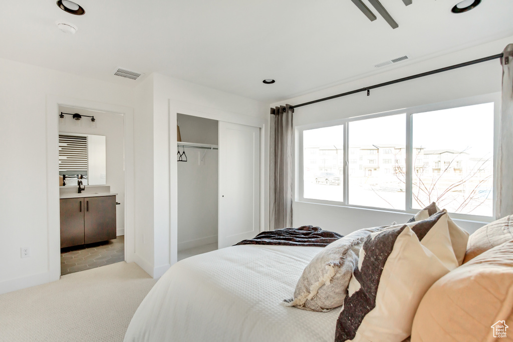 Bedroom featuring carpet floors, a closet, connected bathroom, a sink, and recessed lighting