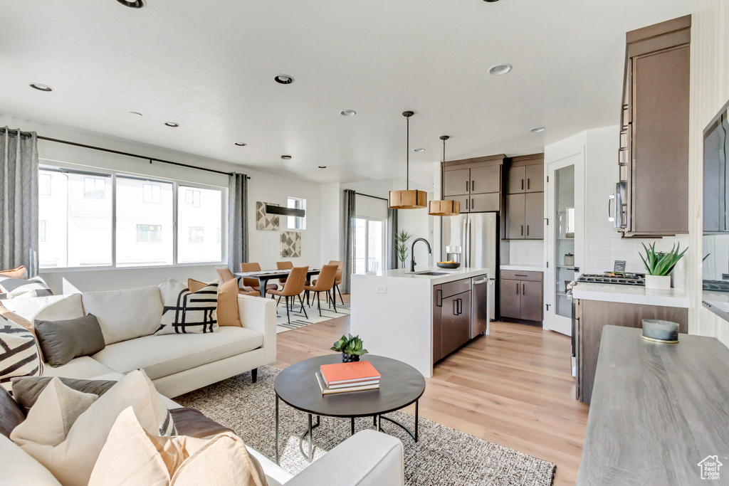 Living area with light wood-style flooring and recessed lighting