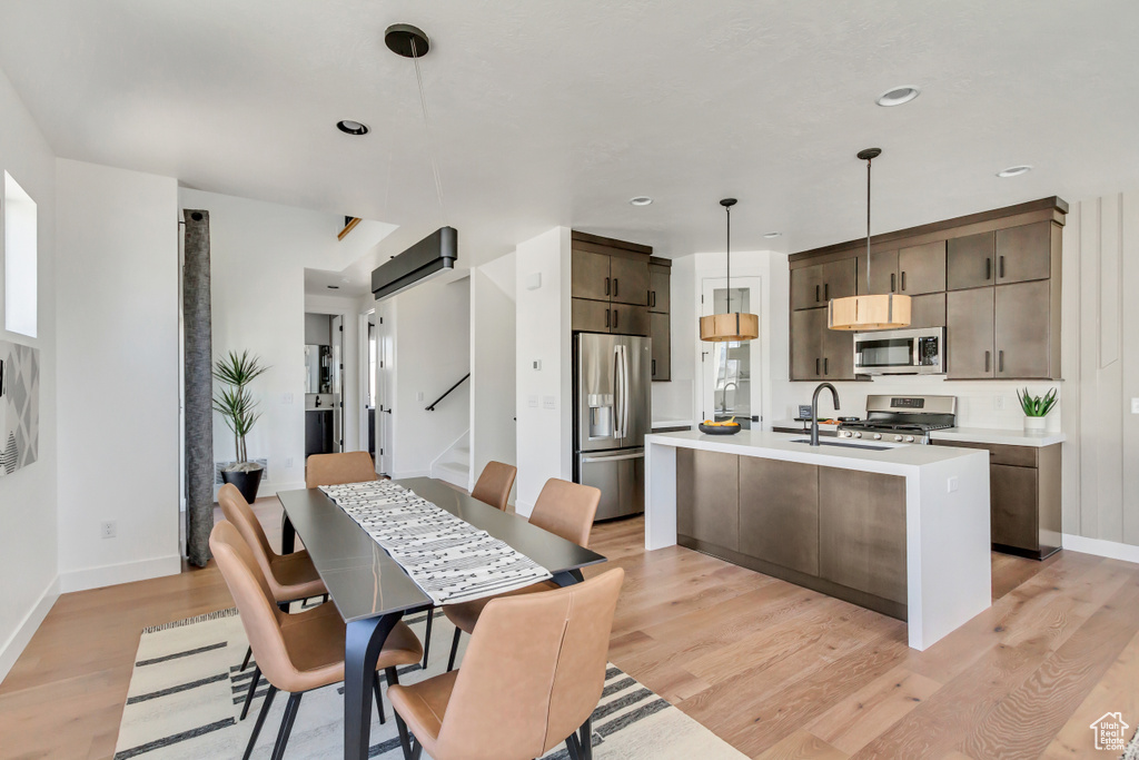 Kitchen with stainless steel appliances, light wood-style flooring, light countertops, baseboards, and recessed lighting