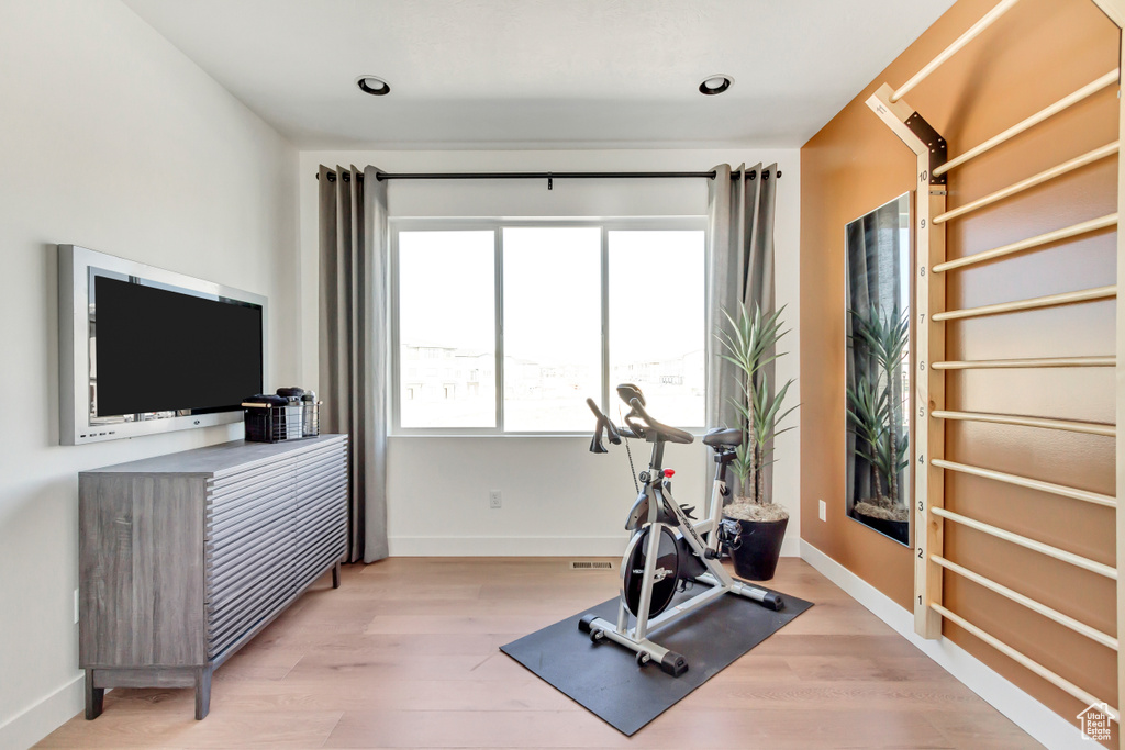 Exercise area with wood finished floors and baseboards