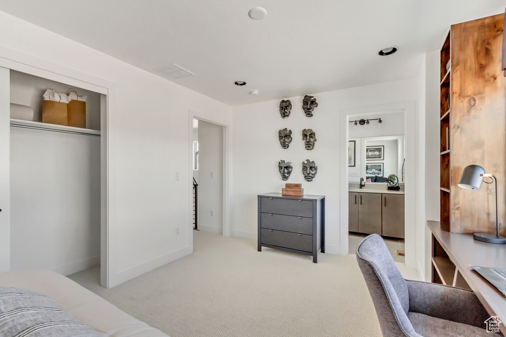 Bedroom with light carpet, a sink, and a closet