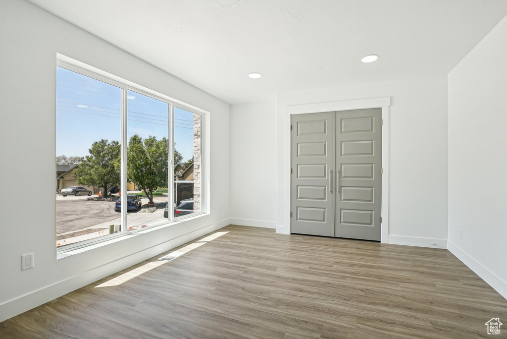 Unfurnished room featuring wood finished floors, baseboards, and recessed lighting
