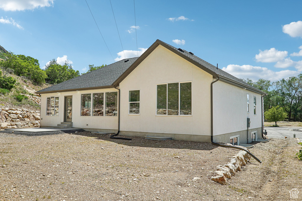Back of property featuring entry steps and stucco siding