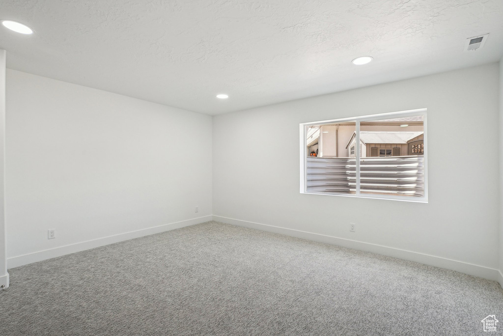 Unfurnished room featuring carpet floors, baseboards, recessed lighting, and a textured ceiling