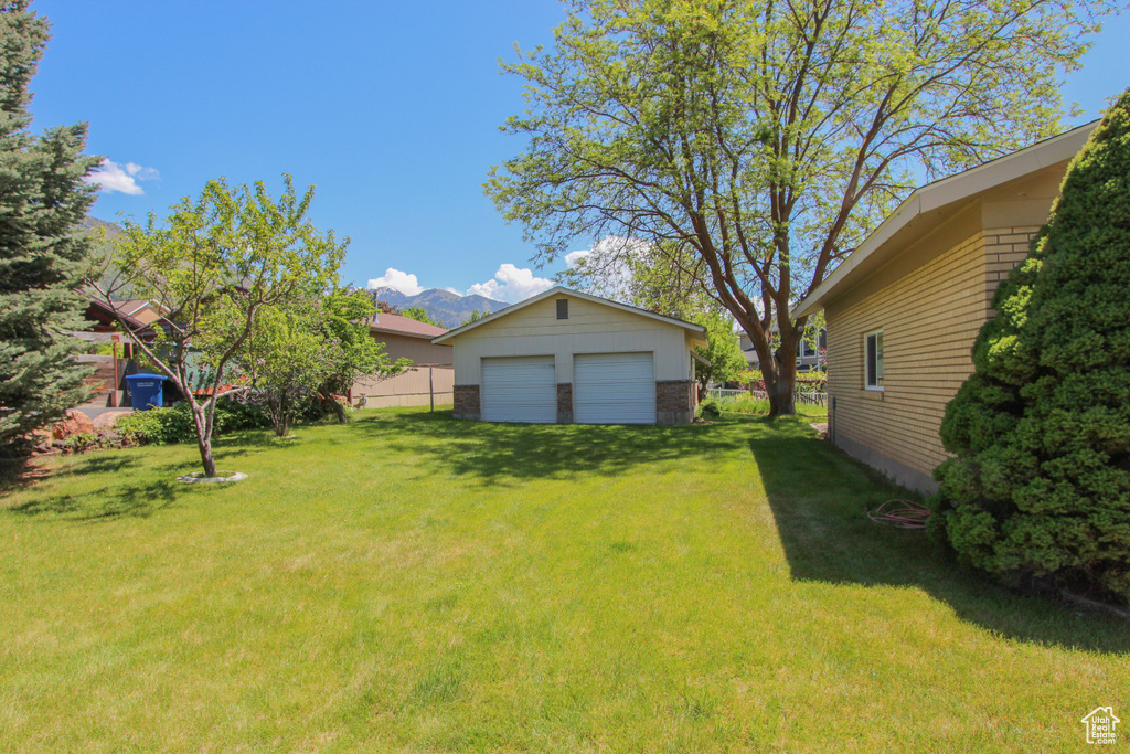 View of yard with a garage, an outbuilding, and a mountain view