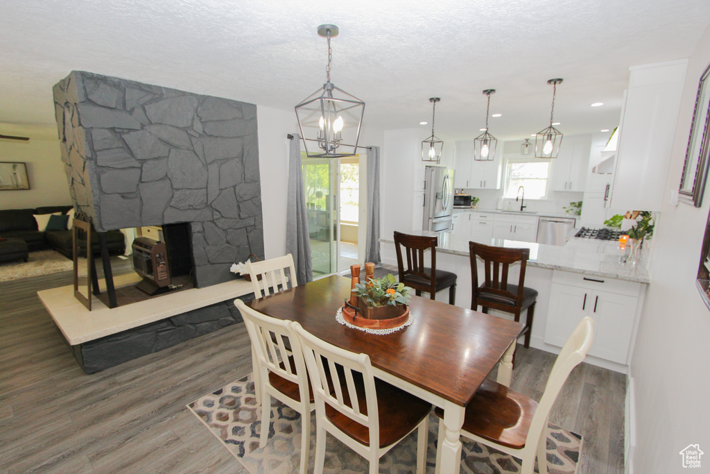 Dining space featuring wood finished floors, a chandelier, and a fireplace