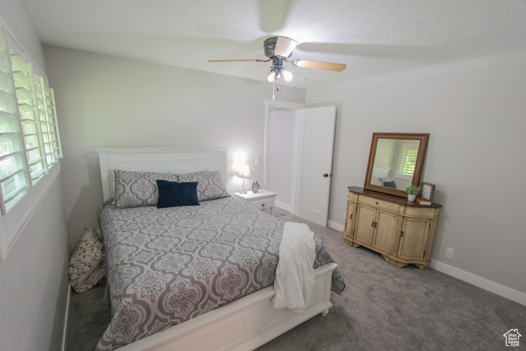 Bedroom with multiple windows, light carpet, and ceiling fan