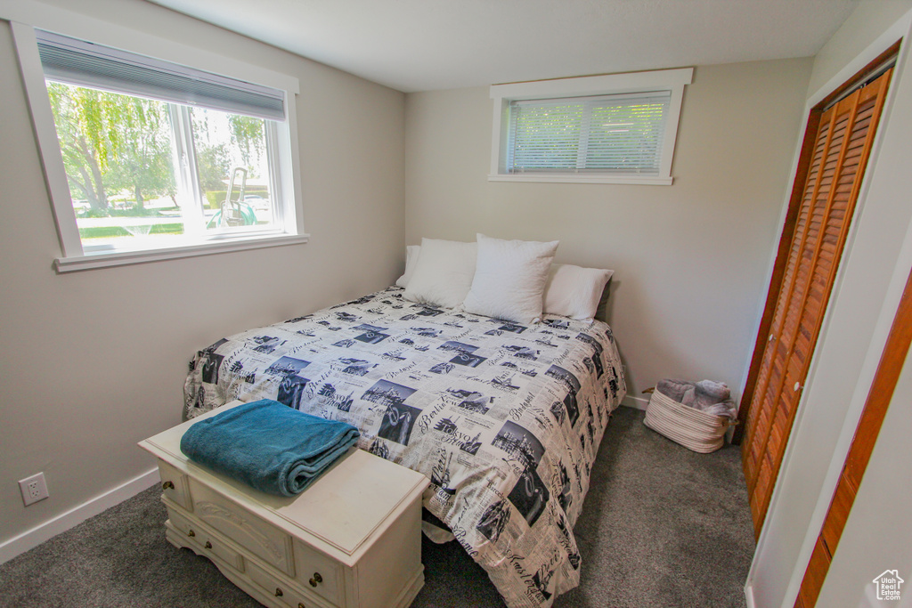 Carpeted bedroom featuring a closet and baseboards